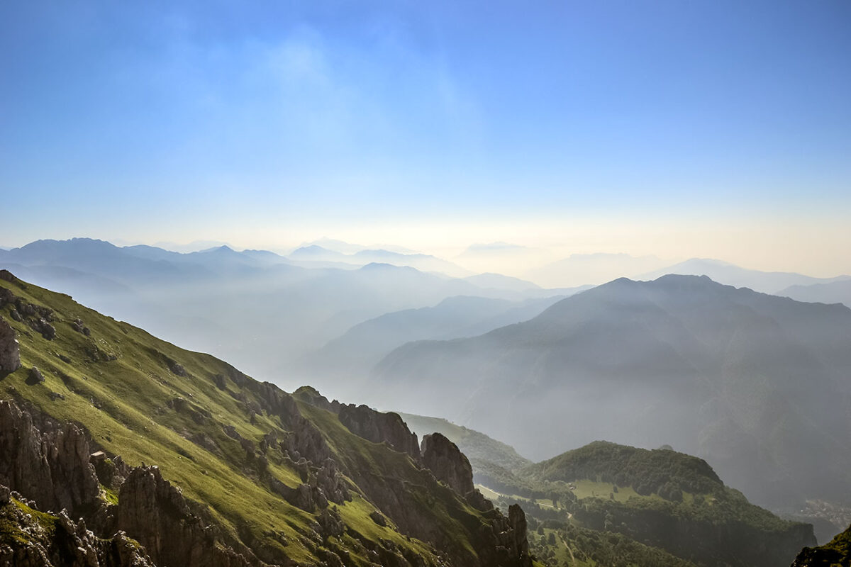 Panoramiczny widok na góry podczas wejścia na Grignettę - widok na skaliste szczyty i doliny, z charakterystycznymi ścieżkami i szlakami turystycznymi, otoczone przez naturalną scenerię górską.