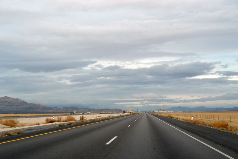 Autostrada diritta che attraversa il paesaggio desertico verso Las Vegas.