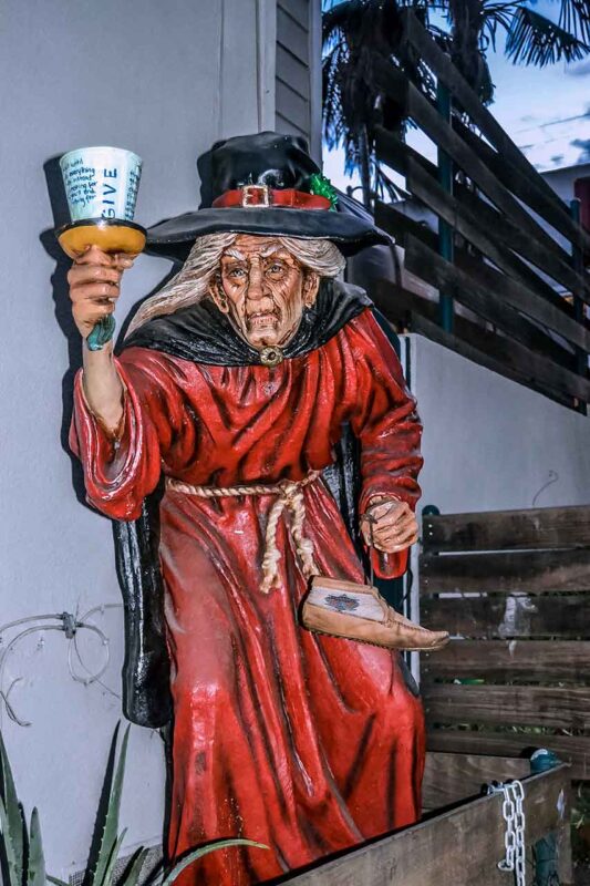 Figurka w kapeluszu trzymająca kubek