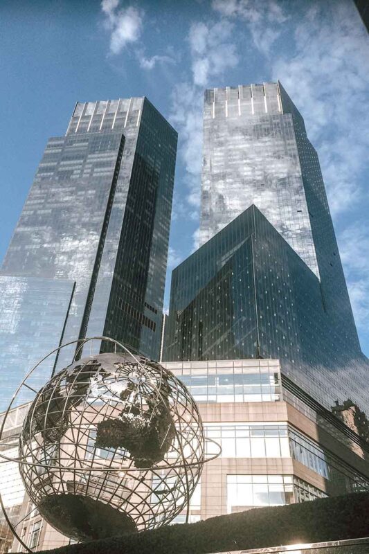 Dwa wysokie wieżowce przy Columbus Circle na tle błękitnego nieba