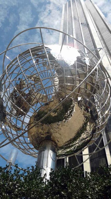 Stalowa rzeźba globusa w Columbus Circle na tle wieżowców