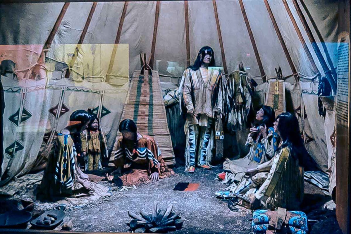 Diorama wnętrza tipi z postaciami w oryginalnych strojach, wyposażenie na ekspozycji