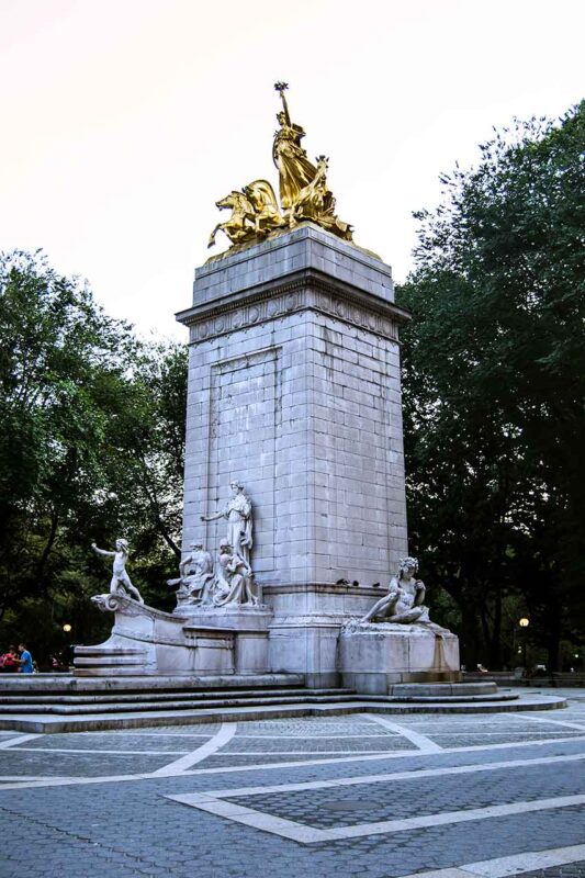Złoty posąg na marmurowym cokole przy Columbus Circle w Nowym Jorku
