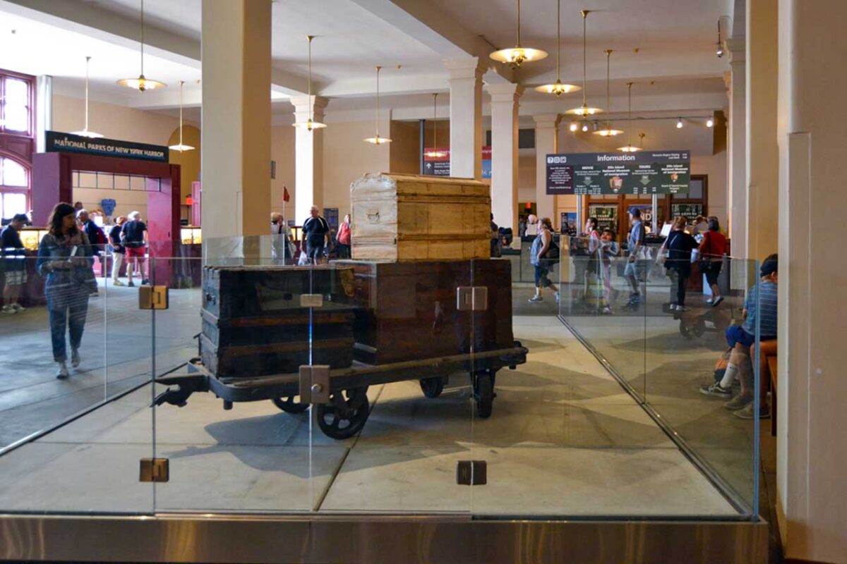 Hol główny Muzeum Imigracji z walizkami i odwiedzającymi