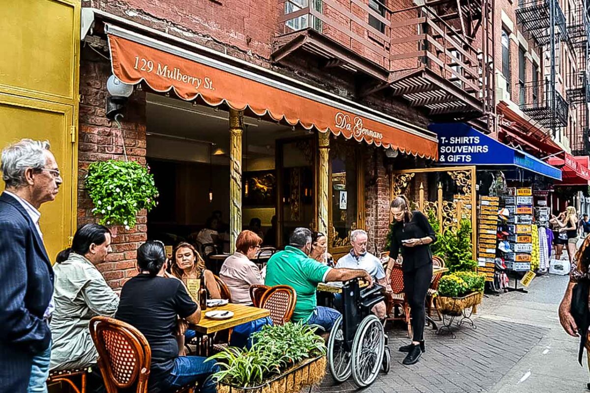 Ludzie siedzący w ogródku kawiarnianym przy Mulberry Street