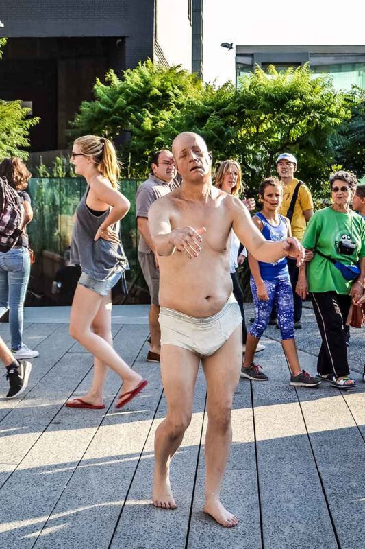Statua realistica di un uomo in biancheria intima nel parco High Line di New York.