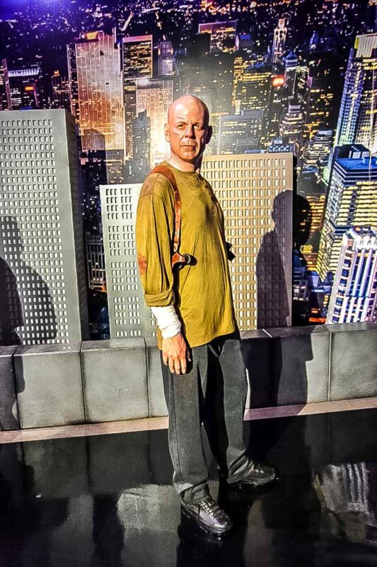 Osoba przy balustradzie z widokiem na Times Square i nowojorskie wieżowce