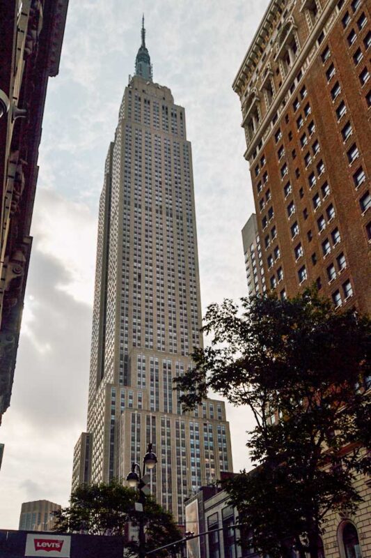 Widok na Empire State Building zza narożnego budynku, poniżej szczytu wieżowca