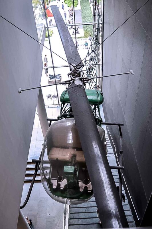 Wysoka rzeźba z wahadłem i mechanizmami rozwieszona w wysokim hallu muzeum