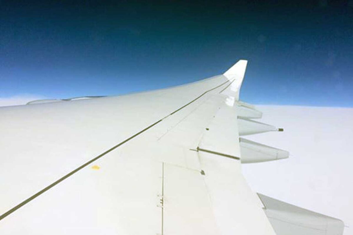 Ala di un aereo vista dal finestrino durante un volo sopra le nuvole.