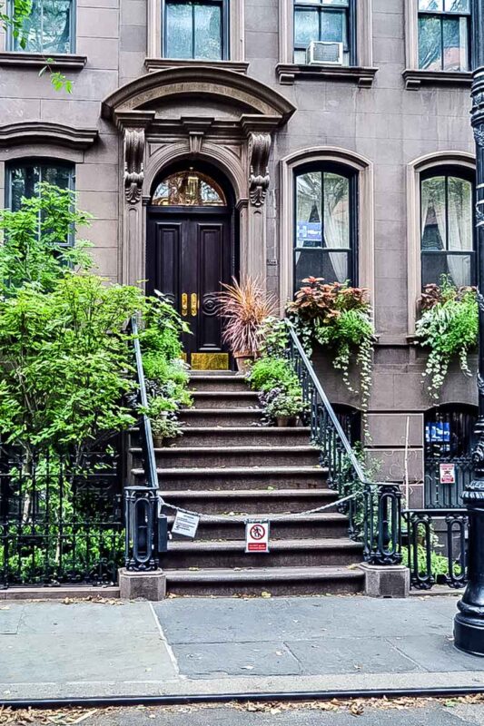 Classica palazzina di New York con scalinata decorativa, location della serie cult.