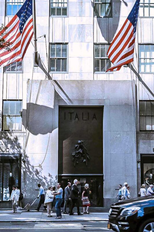 Budynek Rockefeller Center z amerykańskimi flagami na tle jasnej fasady