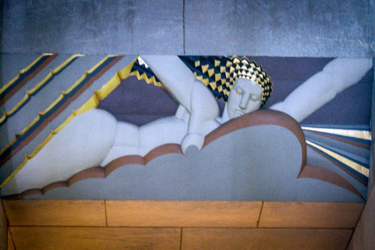 Kolorowy mural przedstawiający skrzydlate postaci na tle geometrycznych kształtów