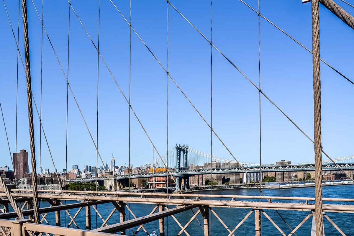 Manhattan Bridge widziany przez liny konstrukcji Brooklyn Bridge