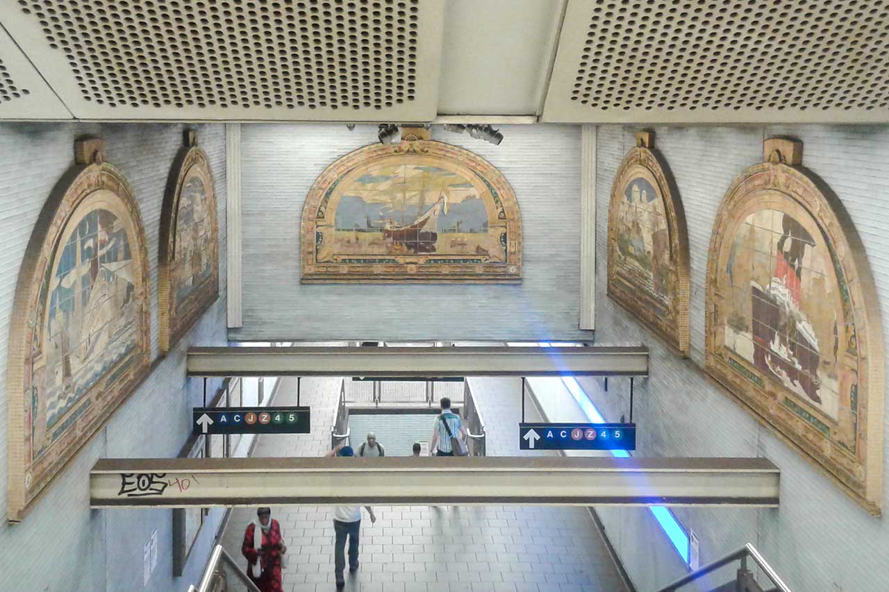 Stazione della metropolitana di New York con mosaici Scale che conducono alla banchina della metropolitana di New York con mosaici storici sulle pareti
