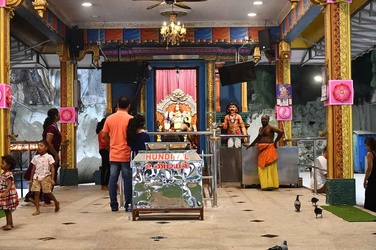 Wnętrze świątyni w Batu Caves w Kuala Lumpur z wiernymi i dekoracjami