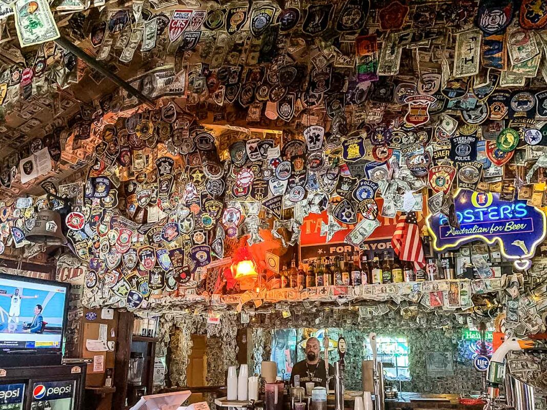 Barwne wnętrze No Name Pub, pokryte dolarowymi banknotami i suwenirami