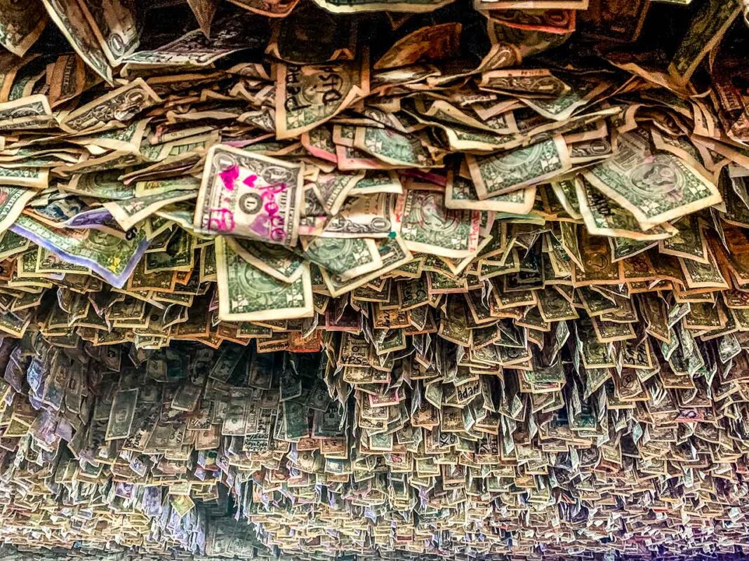 Ściana dosłownie pokryta banknotami dolarowymi, ręcznie podpisanymi przez gości