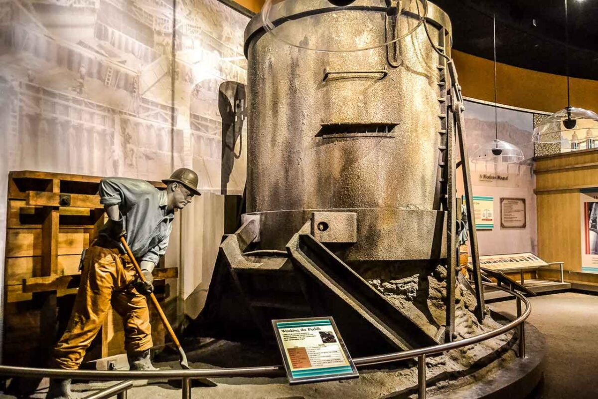 Esposizione del museo della Diga di Hoover con la figura di un operaio degli anni '30 accanto a una struttura in cemento.