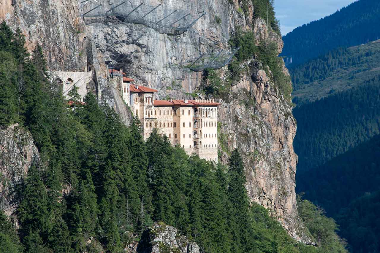 monastero di Sumela, situato in alto su una scogliera nelle montagne pontiche in Turchia, integrato nel paesaggio montano, con vista sulle foreste e sulle rocce circostanti