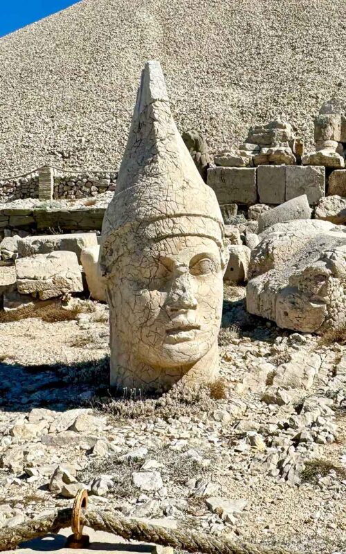 Imponujący posąg Apolla na Górze Nemrut w Turcji, będący częścią monumentalnego sanktuarium z I wieku p.n.e., które łączy elementy greckie i perskie, świadcząc o synkretyzmie religijnym tamtego okresu.