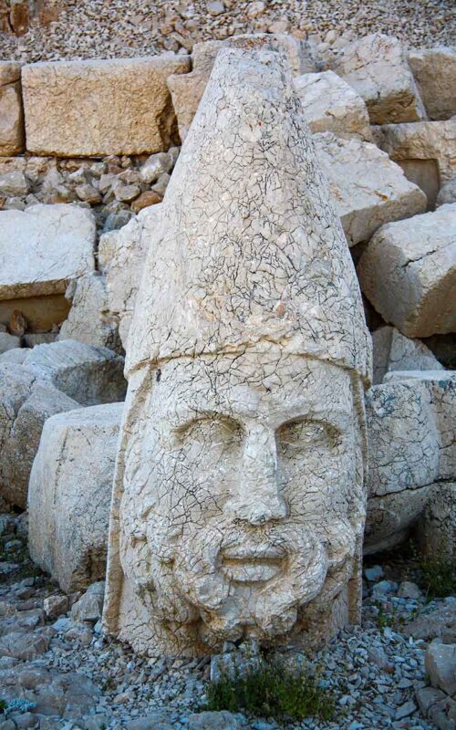 Posąg Heraklesa na Górze Nemrut w Turcji, będący synkretycznym połączeniem greckiego herosa i perskiego bóstwa Artagnesa, symbolizujący siłę i męstwo w starożytnym Królestwie Kommageny.