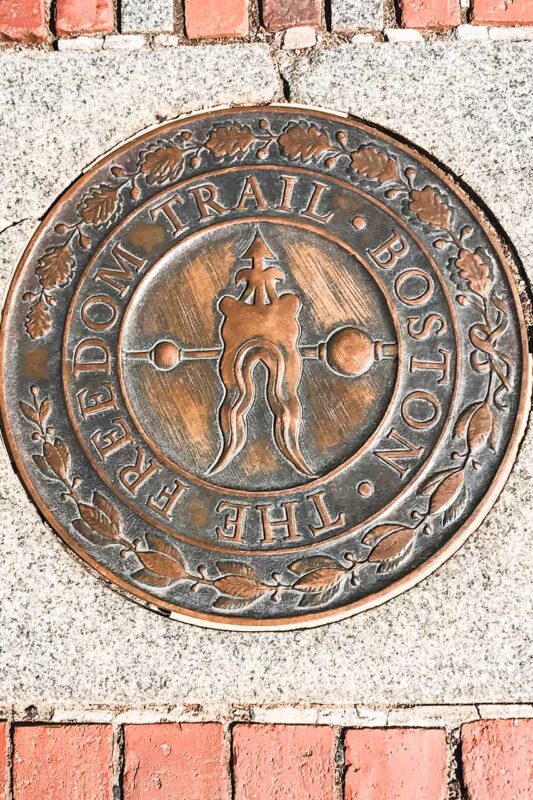 Sentiero rosso lastricato del Boston Freedom Trail che attraversa i luoghi storici della città, facilitando la visita dei punti chiave della rivoluzione americana