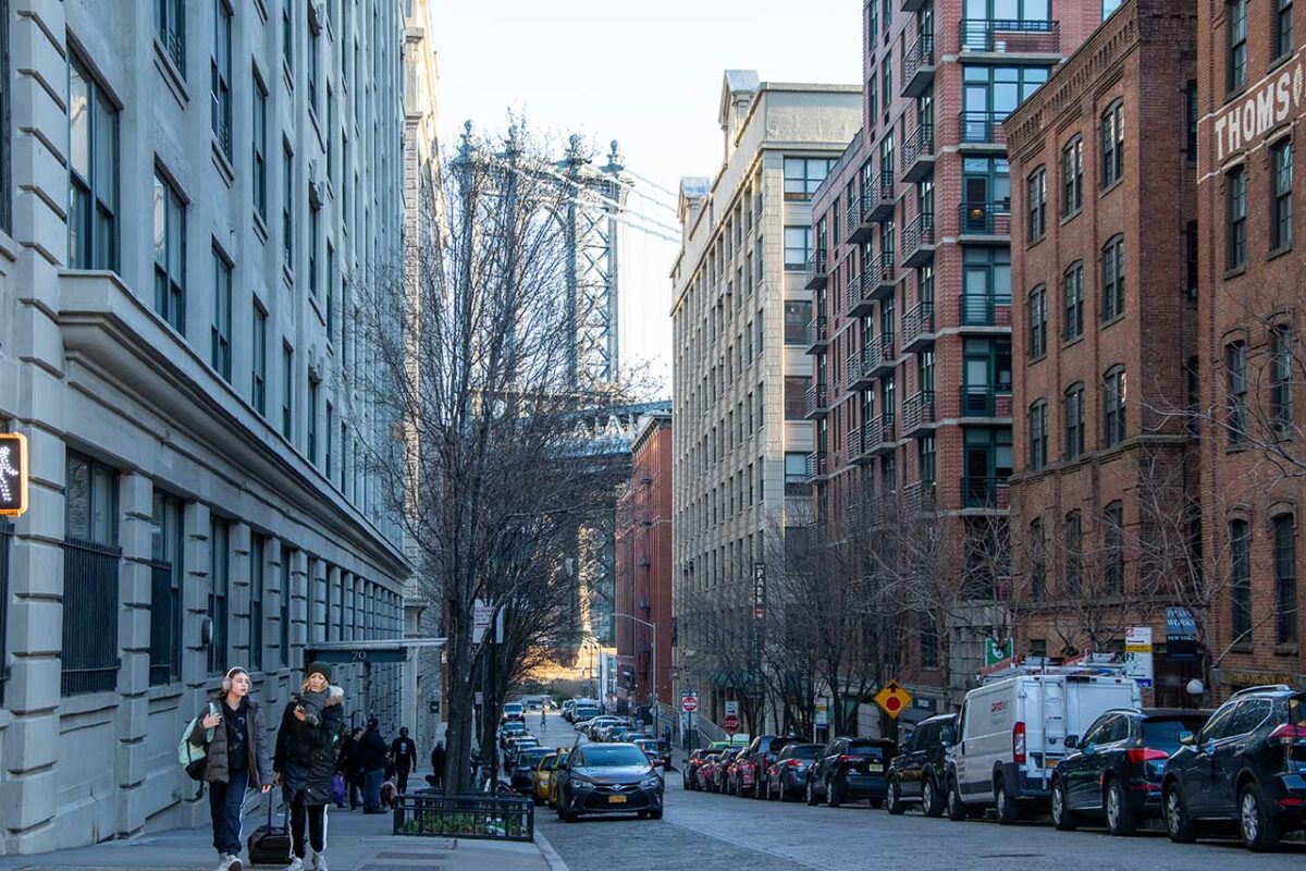 Persone che camminano tra i loft industriali nel quartiere DUMBO di Brooklyn.