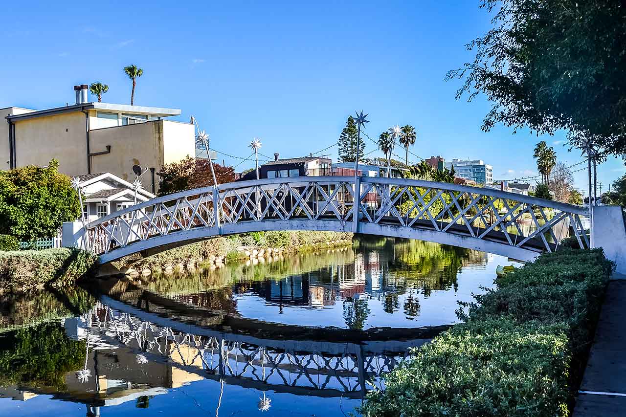 Canale a Venice Beach con palme e ponte bianco