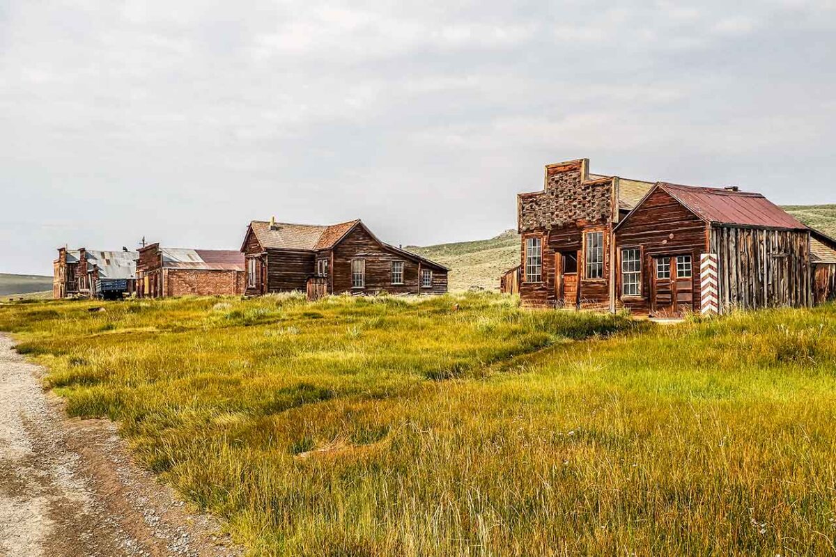 Veduta panoramica della città fantasma di Bodie da una strada sterrata con edifici in legno del XIX secolo.