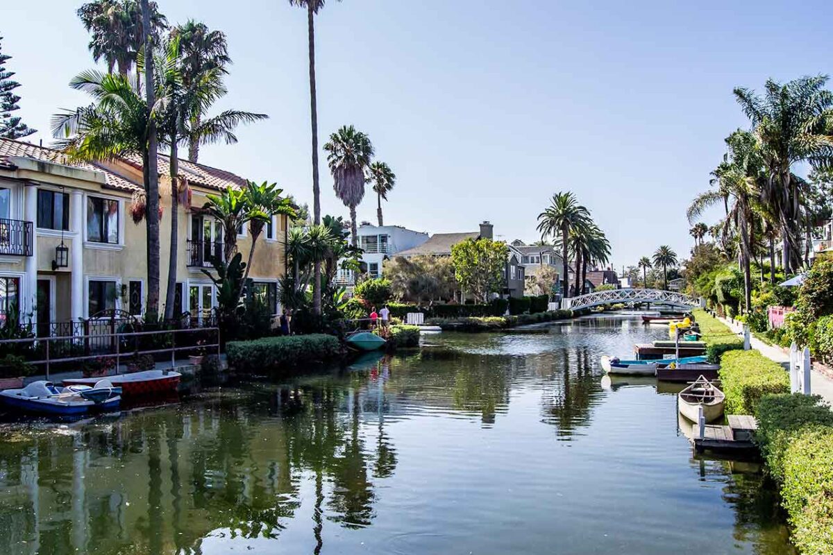 Casa lungo il canale a Venice Beach con ponte, palme e barche