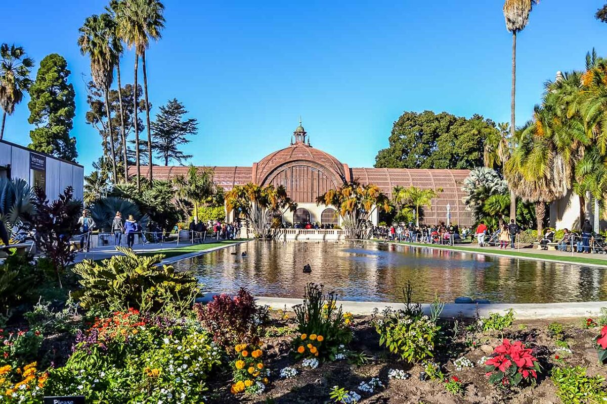 Botanical Building a Balboa Park a San Diego, circondato da palme e fiori, con riflesso nello stagno