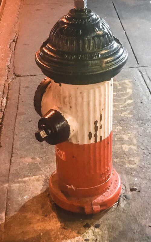 Hydrant pomalowany w kolory flagi włoskiej – zielony, biały i czerwony, stojący na chodniku w Little Italy.