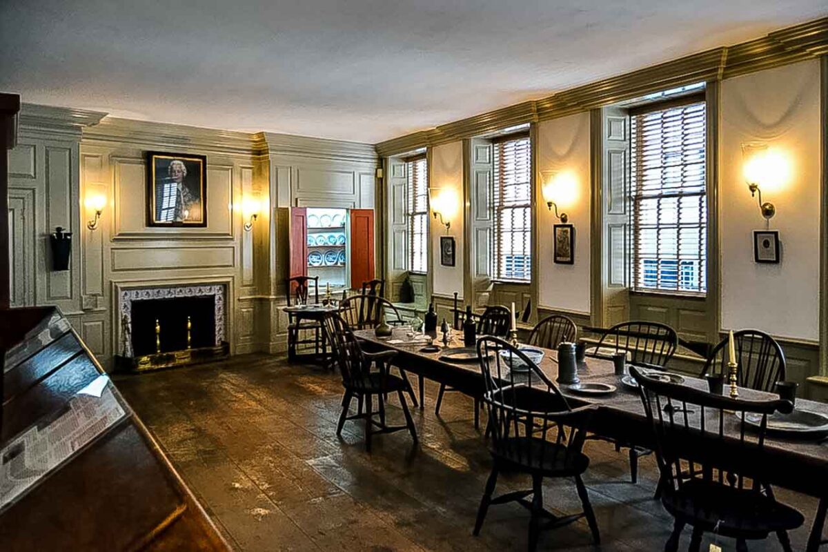 Zabytkowa sala jadalna we Fraunces Tavern z długim stołem i kominkiem