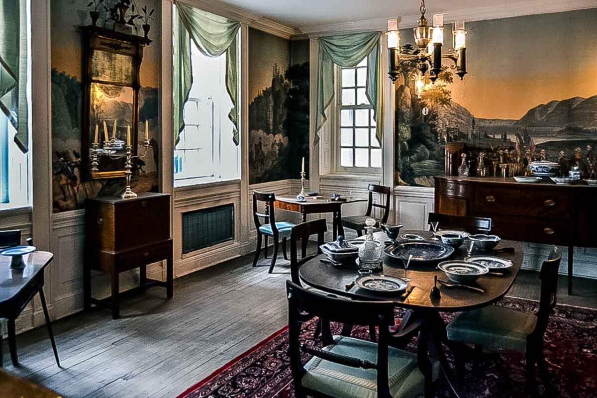 Historyczna jadalnia we Fraunces Tavern z nakrytym stołem i malowidłami na ścianach