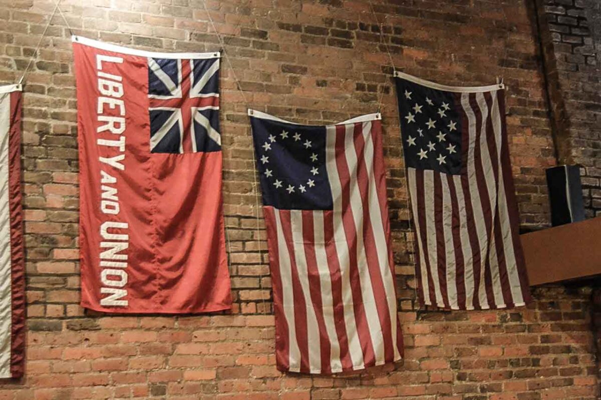 Historyczne flagi wiszące na ceglanej ścianie we Fraunces Tavern