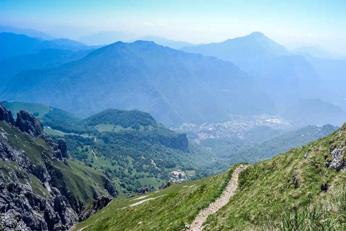Widok na pionowe skały i panoramę Alp z trasy na Grignetta