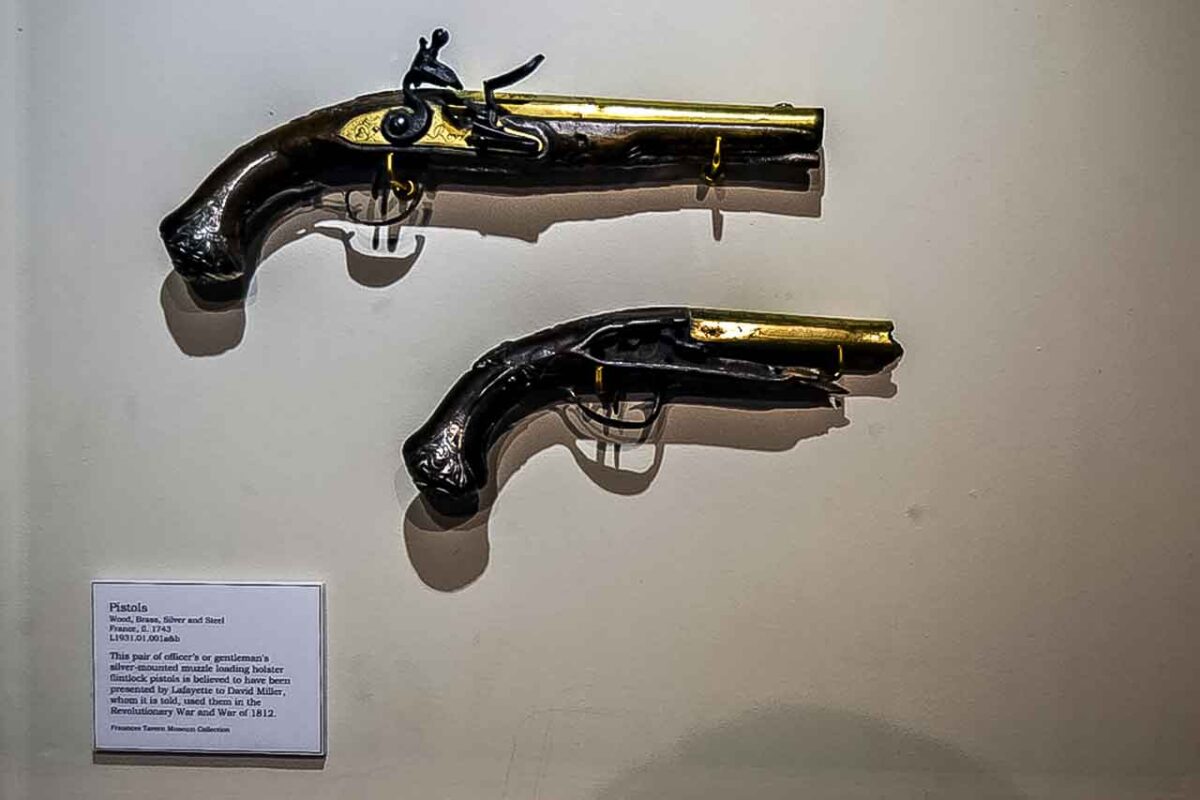 Dwa zabytkowe pistolety pokazane na ścianie muzeum Fraunces Tavern